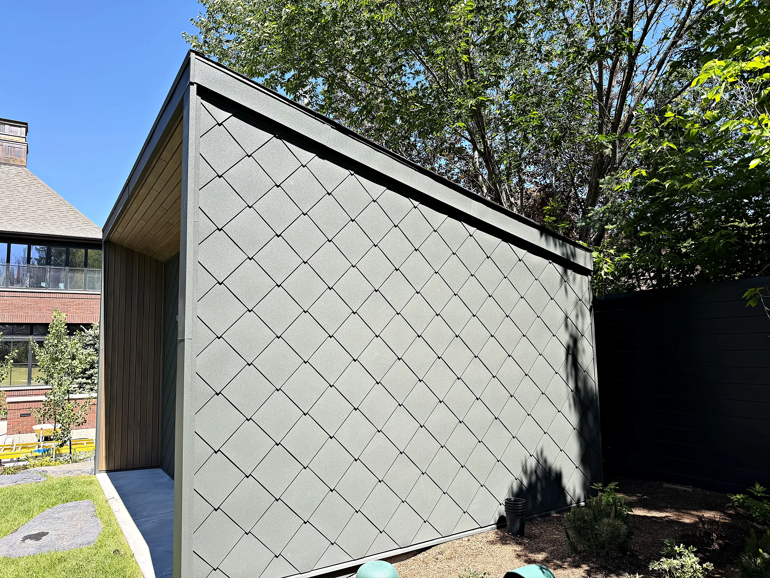 Garden shed clad in diamond-pattern zinc
