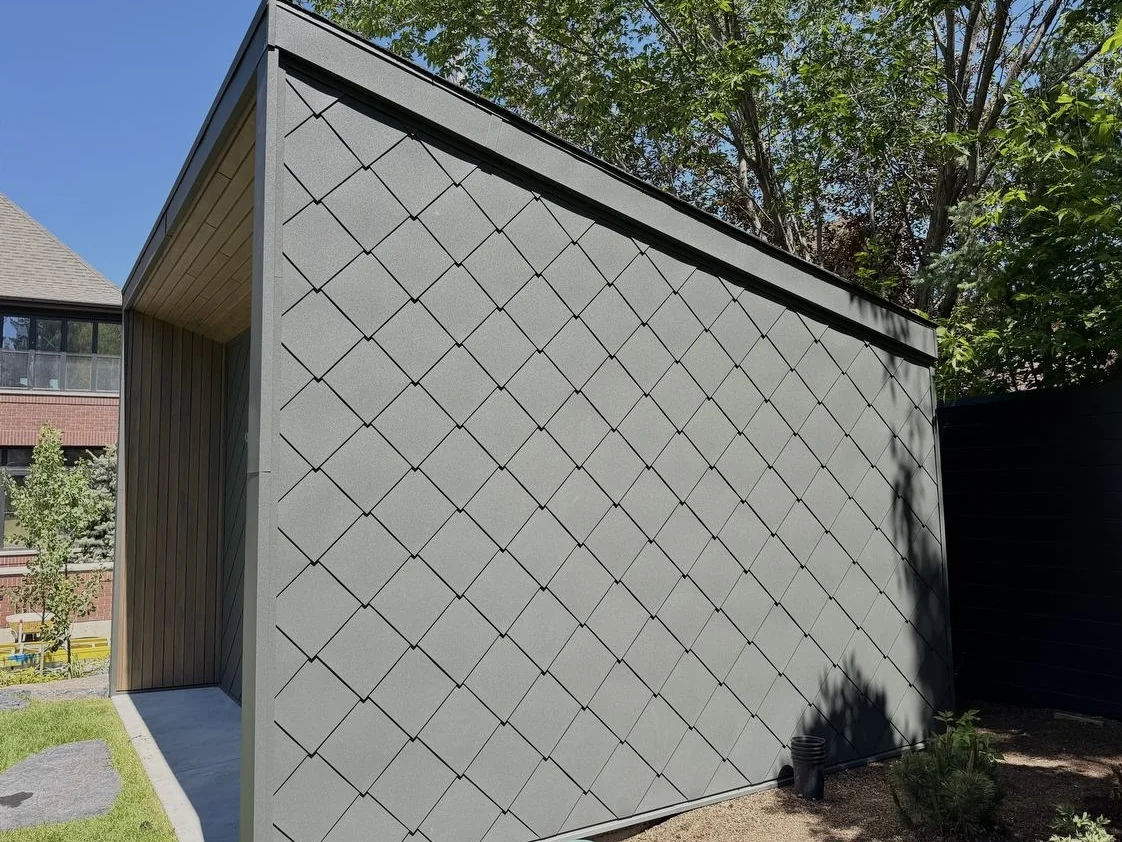 Diamond-pattern zinc cladding on a garden building