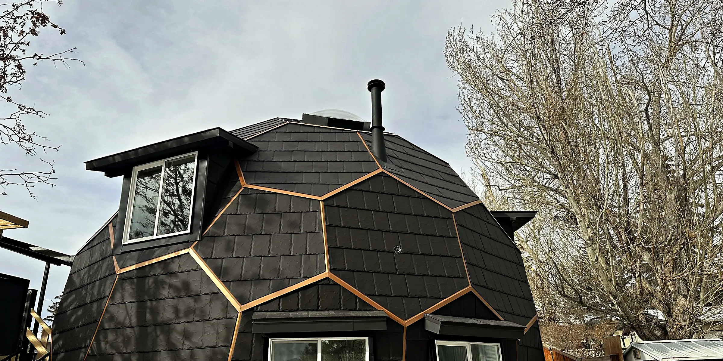 Geodesic dome clad in metal shingles with bronze-coloured trim