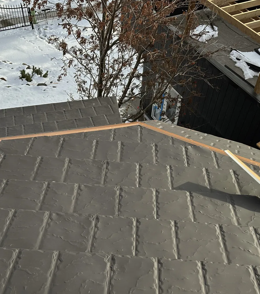 Metal shingles and bronze-coloured trim close up