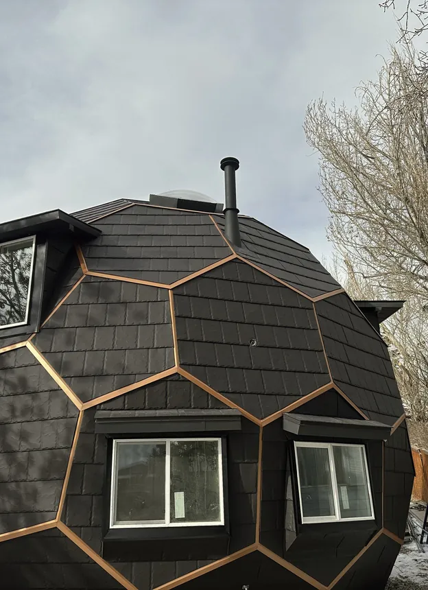 Geodesic dome clad in metal shingles with bronze-coloured trim