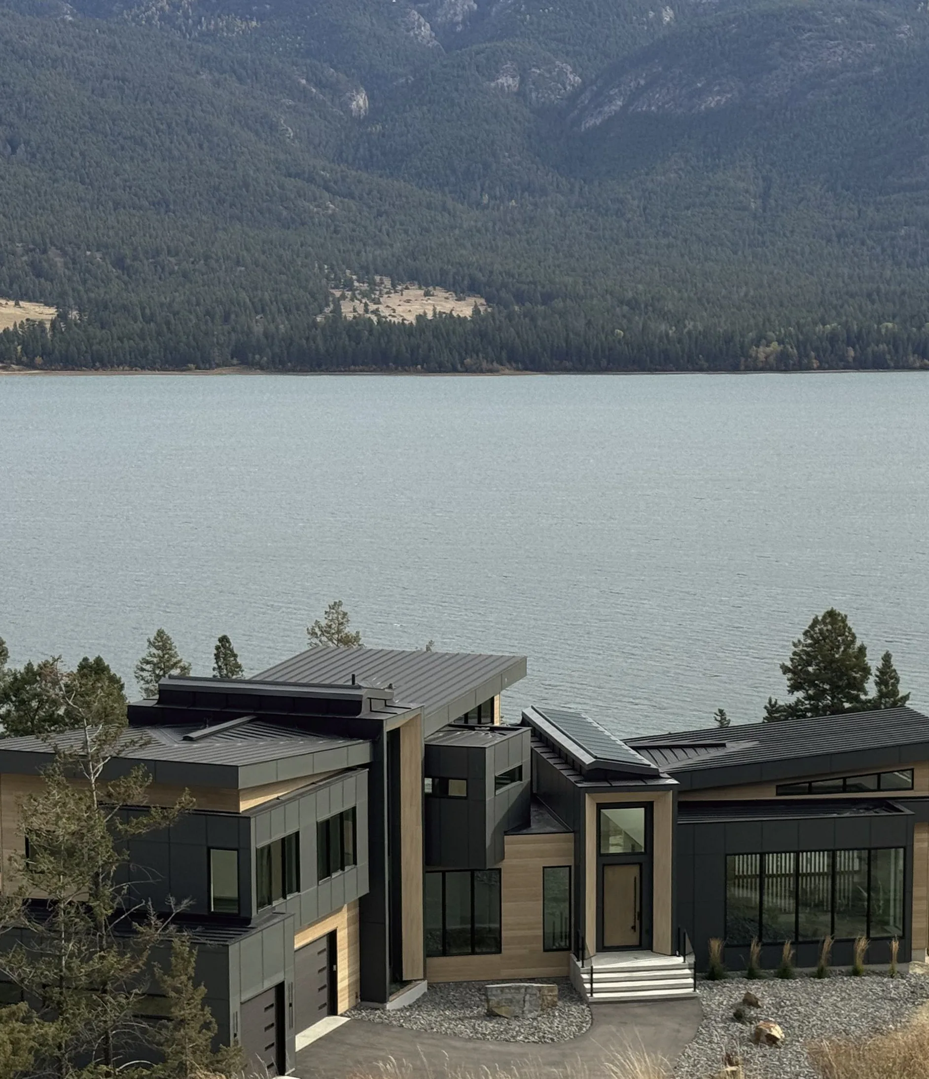 Mountain home with a metal roof by a lake